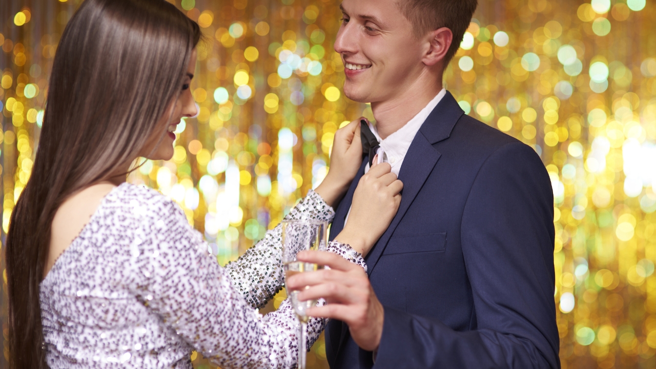 Devojka namešta leptir mašnu partneru kako bi zajedno izgledali skladno za maturu