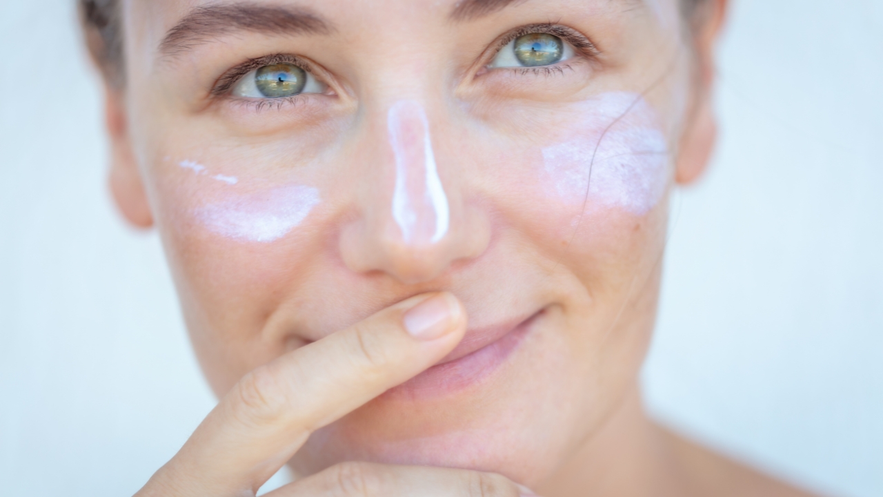 Žena sa SPF kremom na licu pokazuje pravilno nanošenje zaštite od sunca